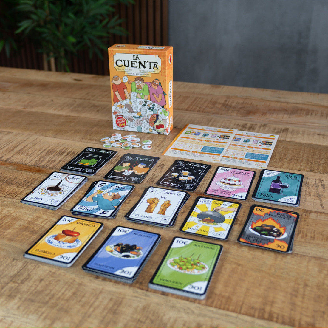 Juego de mesa La Cuenta en caja naranja con cartas, fichas y reglamento sobre mesa de madera