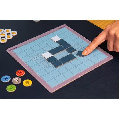 Mano jugando What the Pixel!, juego de mesa party con fichas y tablero azul