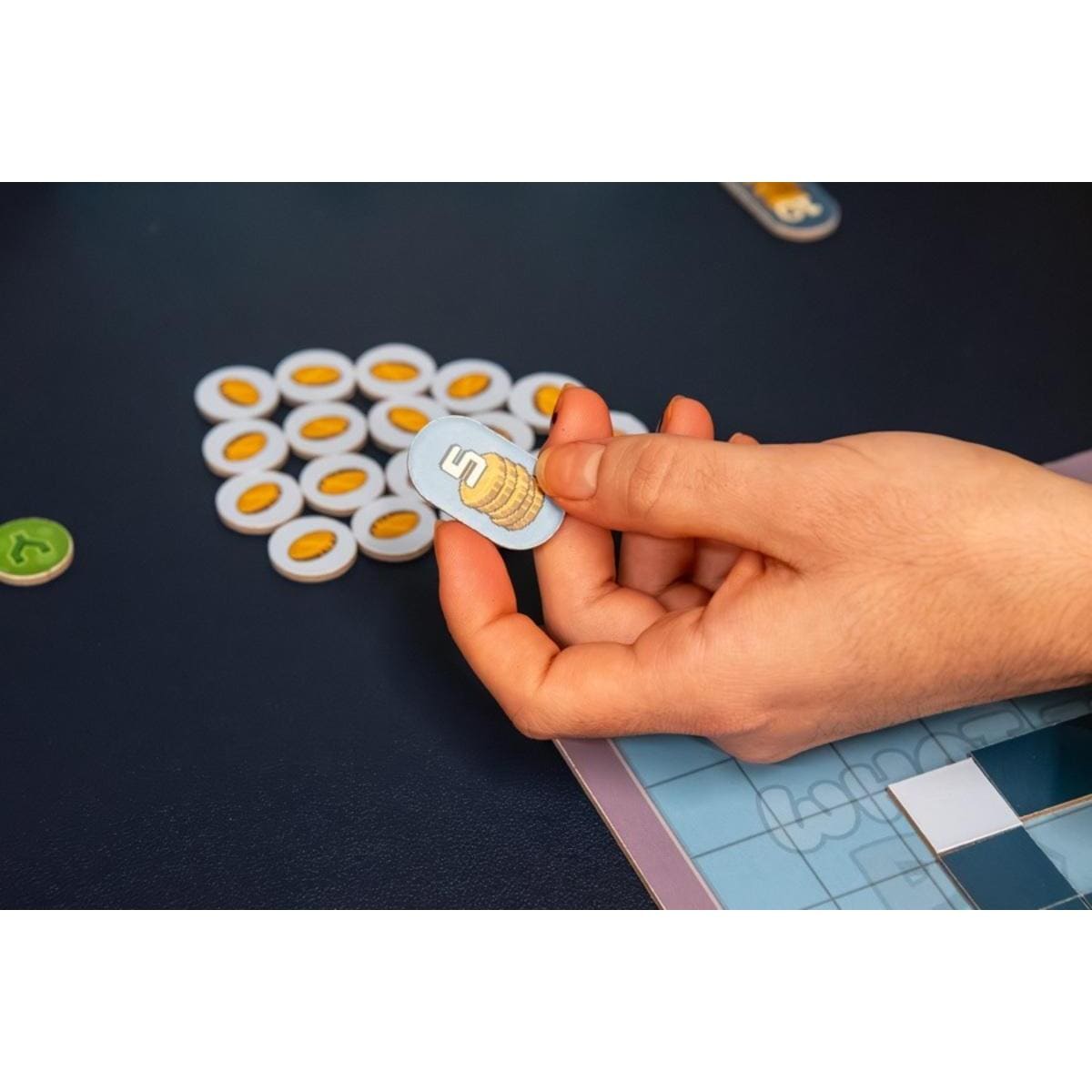 Ficha ovalada azul What the Pixel! con monedas doradas para puntuación en juego