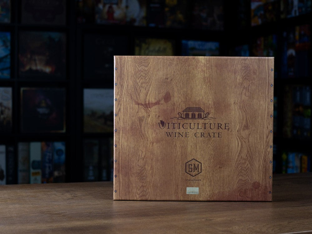 Caja de madera con remaches metálicos y logo Stone Maier Games del juego