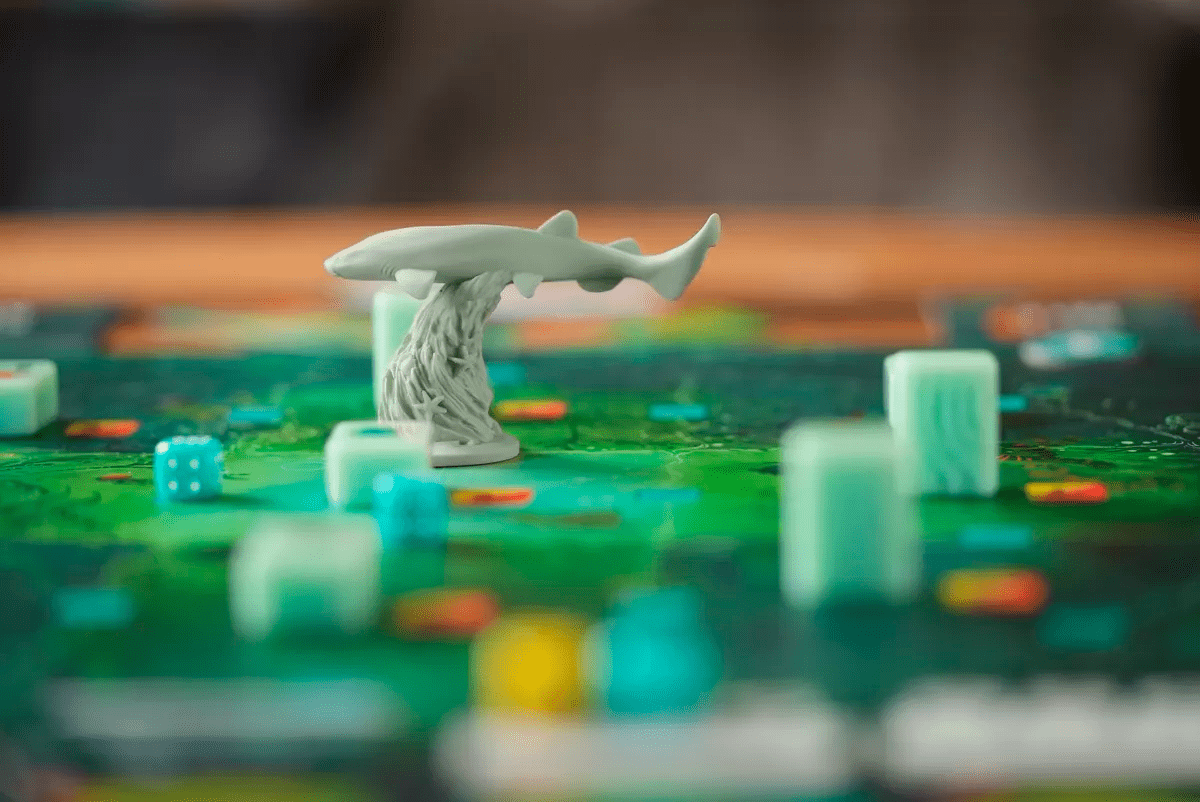 Miniatura de resina de tiburón sobre base de algas en tablero verde