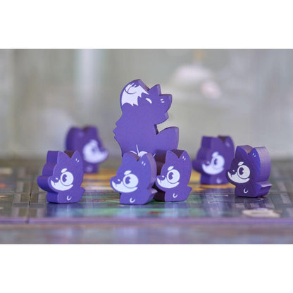 Fichas de madera violetas de monstruos sonrientes y lobo sobre el tablero de juego