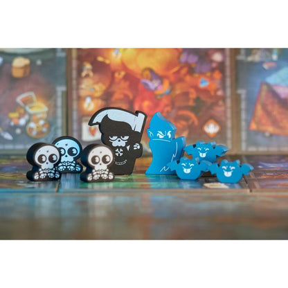 Fichas fantasmales negras y azules con calaveras y grimorios dispuestas en el tablero