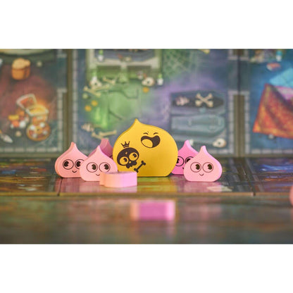Figuras de slime rosa rodeando al jefe amarillo con corona y calavera en el tablero