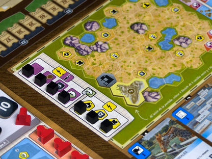 Tablero de juego Ark Nova con terreno hexagonal, cubos de puntuación y carta de jirafa