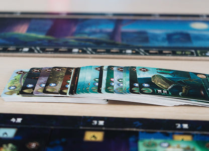 Primer plano de cartas ilustradas con paisajes y símbolos circulares del juego de mesa Ecos del Tiempo