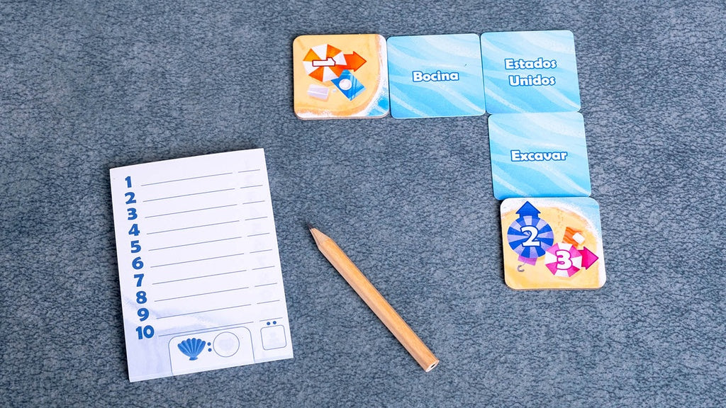Bloc de notas y lápiz junto a cartas del juego cooperativo Perfect Words