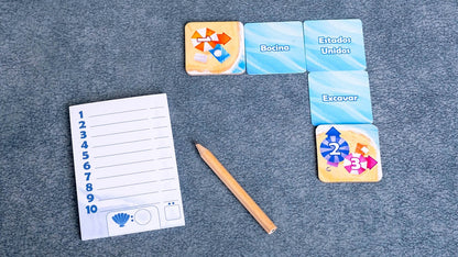 Bloc de notas y lápiz junto a cartas del juego cooperativo Perfect Words