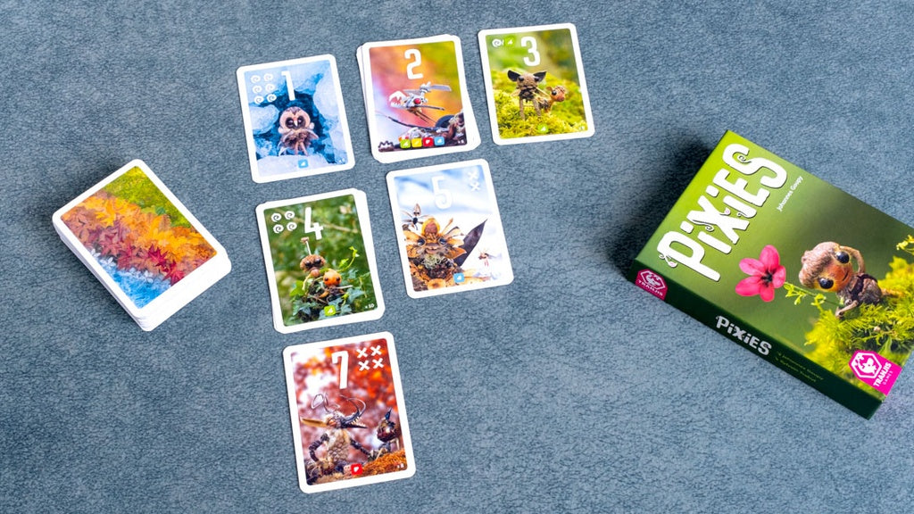 Juego de cartas Pixies vista superior con caja y cartas de bosque mágico