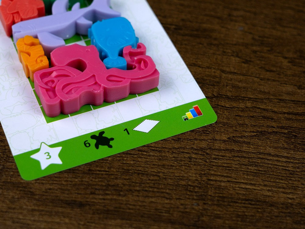Tarjeta desafío nivel 3 con piezas pulpo y tortuga sobre tablero Sea Stax