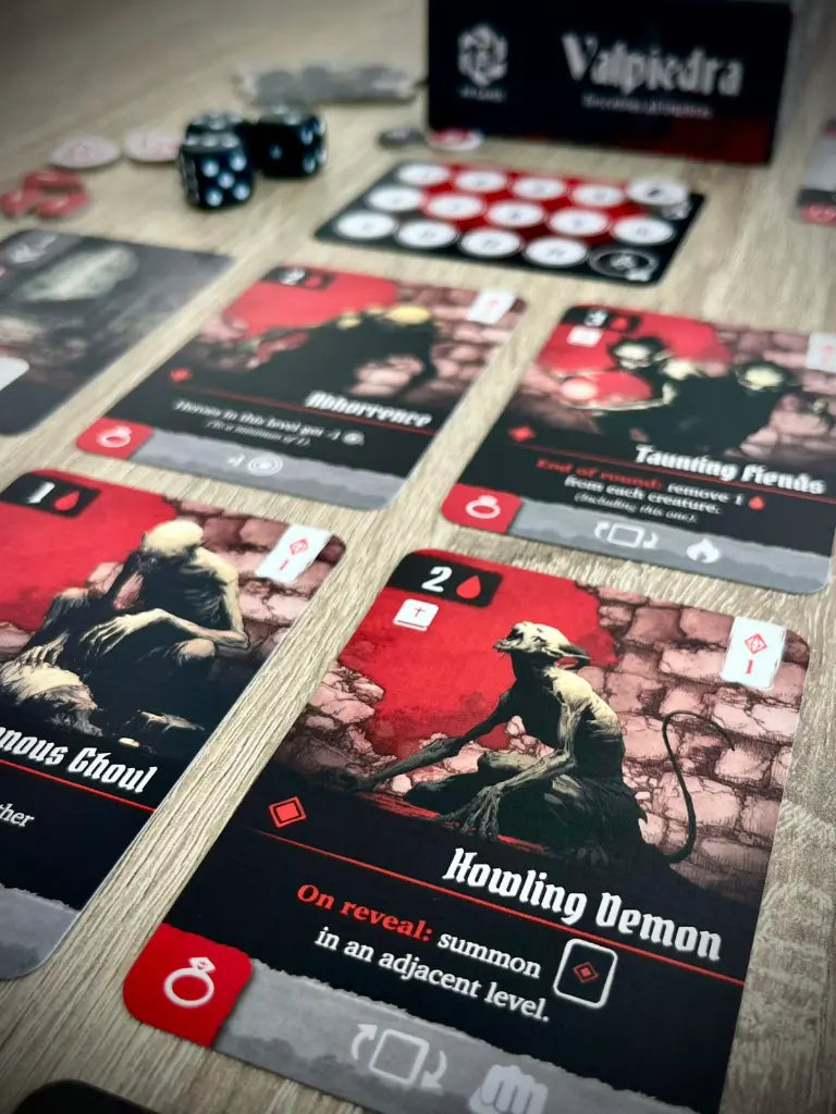 Cartas de monstruos Howling Demon y Abhorrence en partida de Valpiedra con dados y tokens
