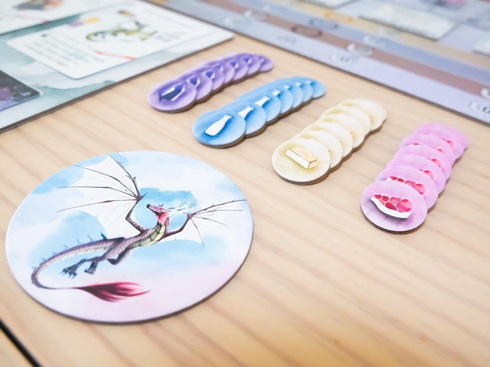 Wyrmspan juego de mesa con componentes circulares y dragón volador