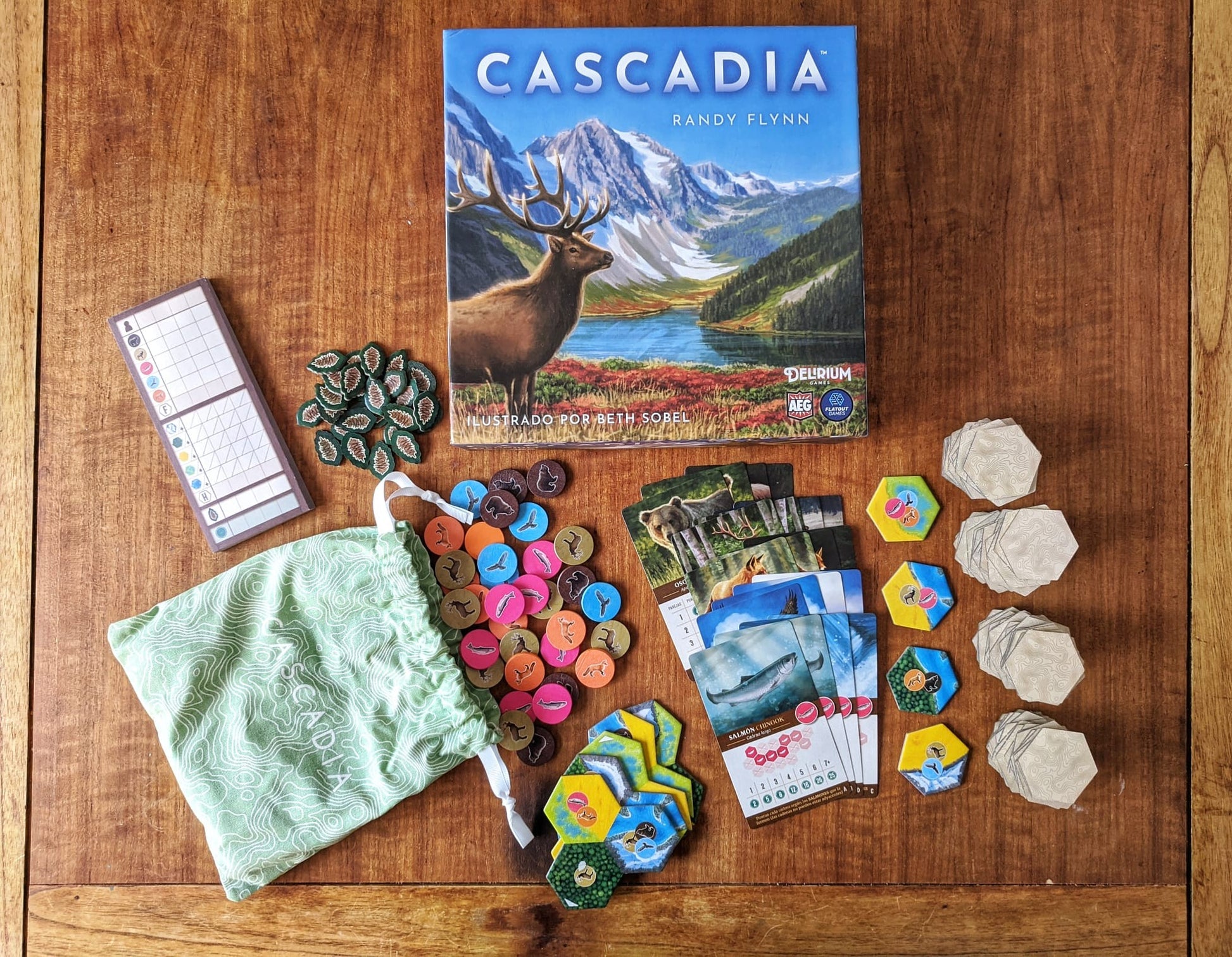 Juego de mesa Cascadia componentes desplegados sobre madera con fichas animales
