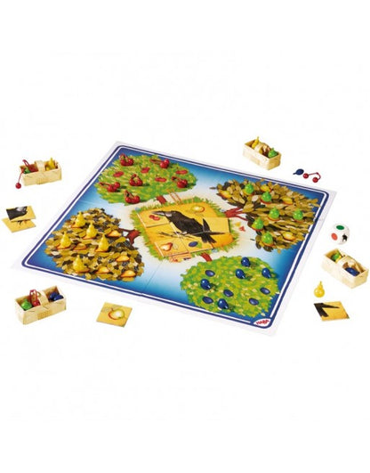 Tablero desplegado juego cooperativo El Frutal HABA con árboles frutales, cuervo y componentes
