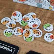 Fichas circulares con valores numéricos del juego de mesa La Cuenta sobre superficie de madera