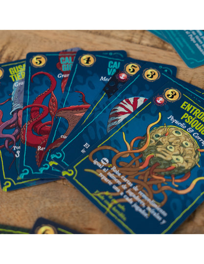 Cartas de juego Deep Regrets mostrando criaturas marinas y símbolos de poder